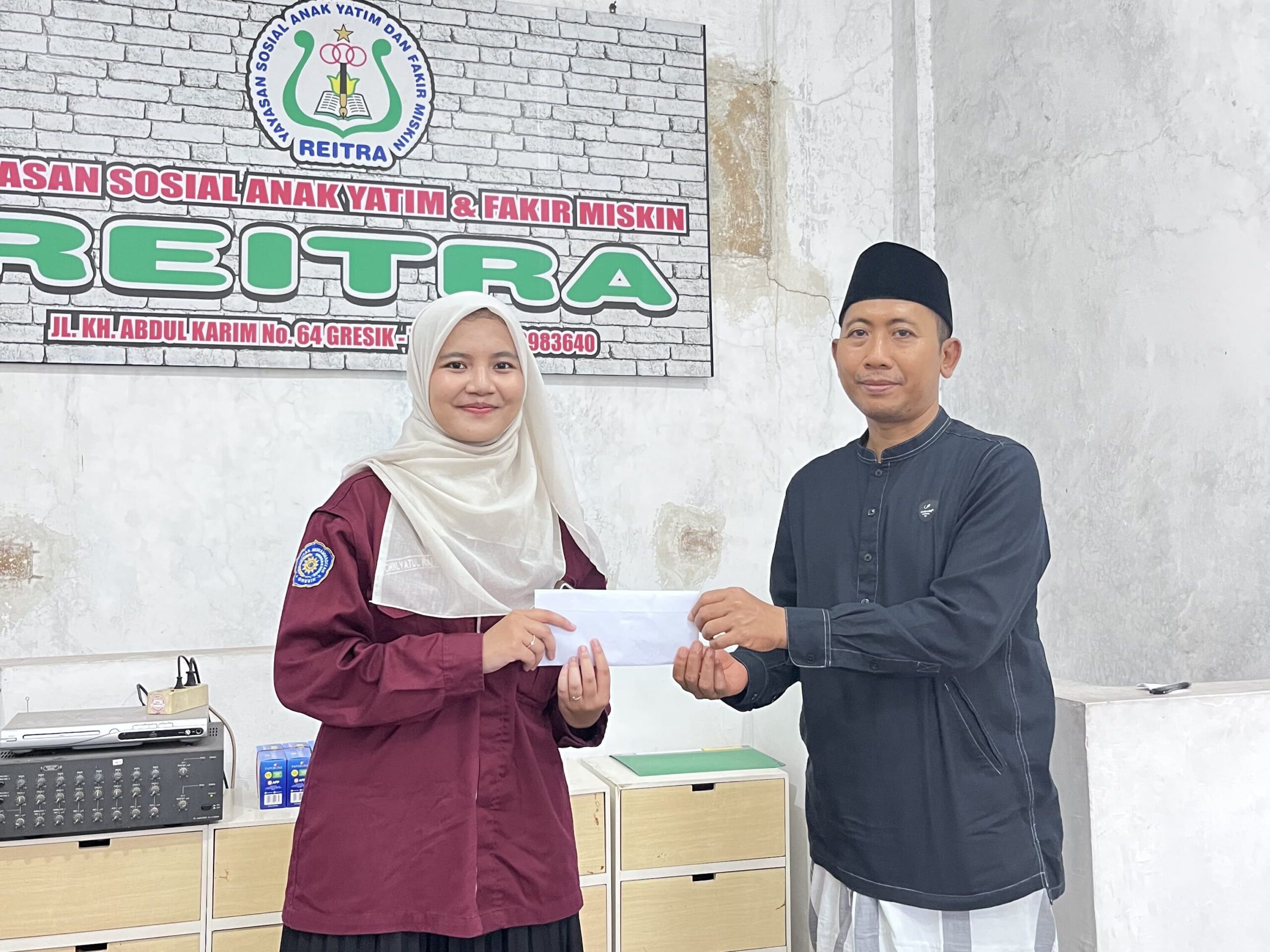 Penyerahan Santunan secara simbolis oleh ketua umum HMTLM Chiilyatul Wafiroh kepada pengurus panti Bapak Purwanto, M.Pd (Nadya/HMTLM)